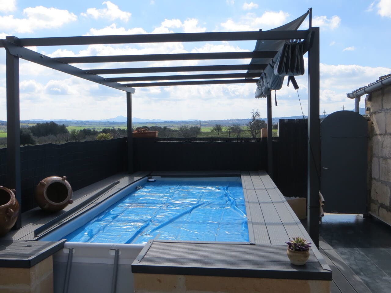 Charmant espace aménager extérieur avec piscine et pergola pour les journées les plus chaudes ou pour protéger les enfants.